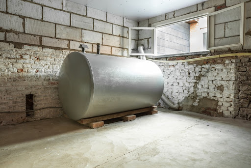 An oil tank in a basement with a brick wall.